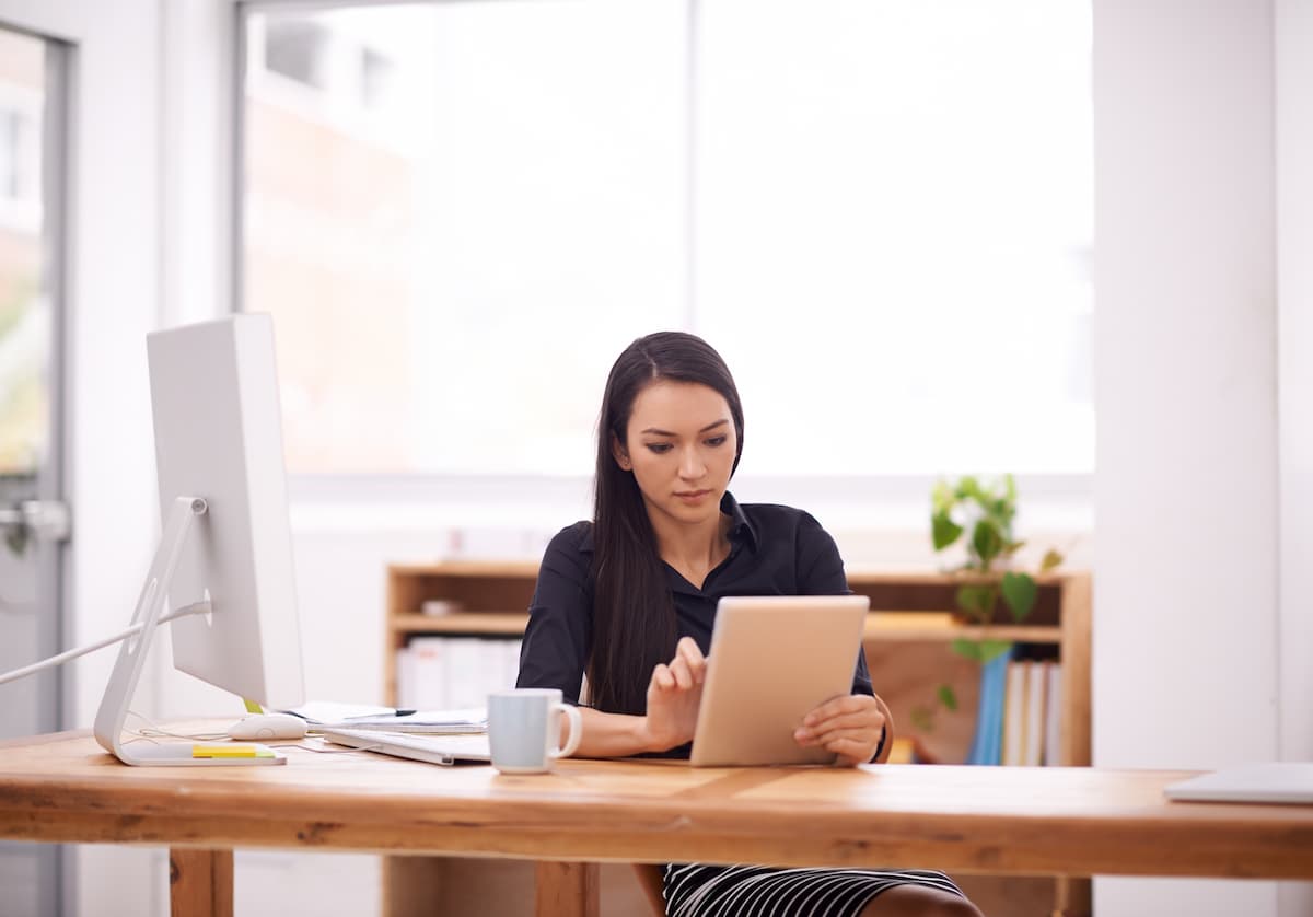 Uma mulher trabalhando com um tablet em seu escritório